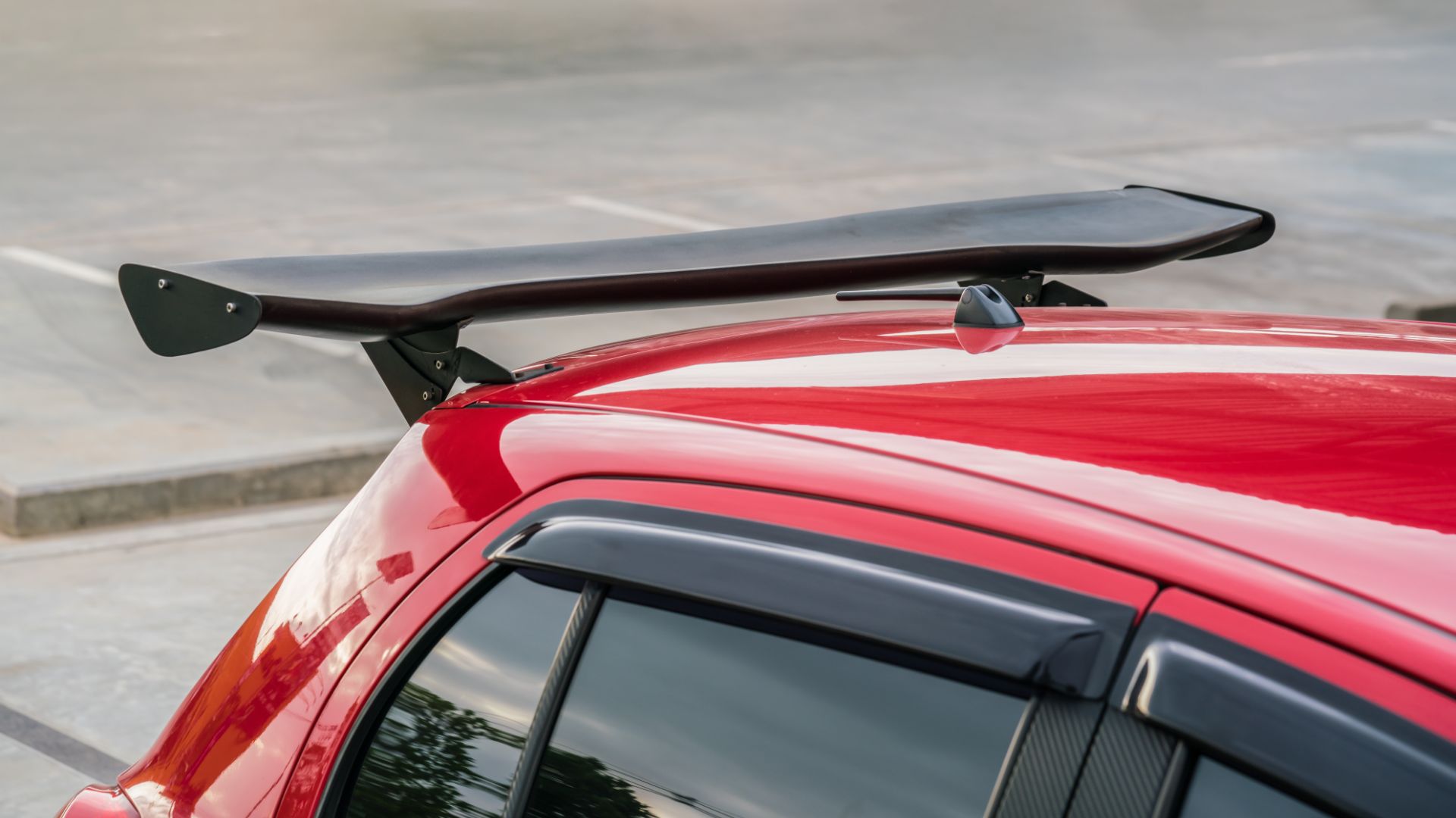 a red car with a surfboard on top of it.