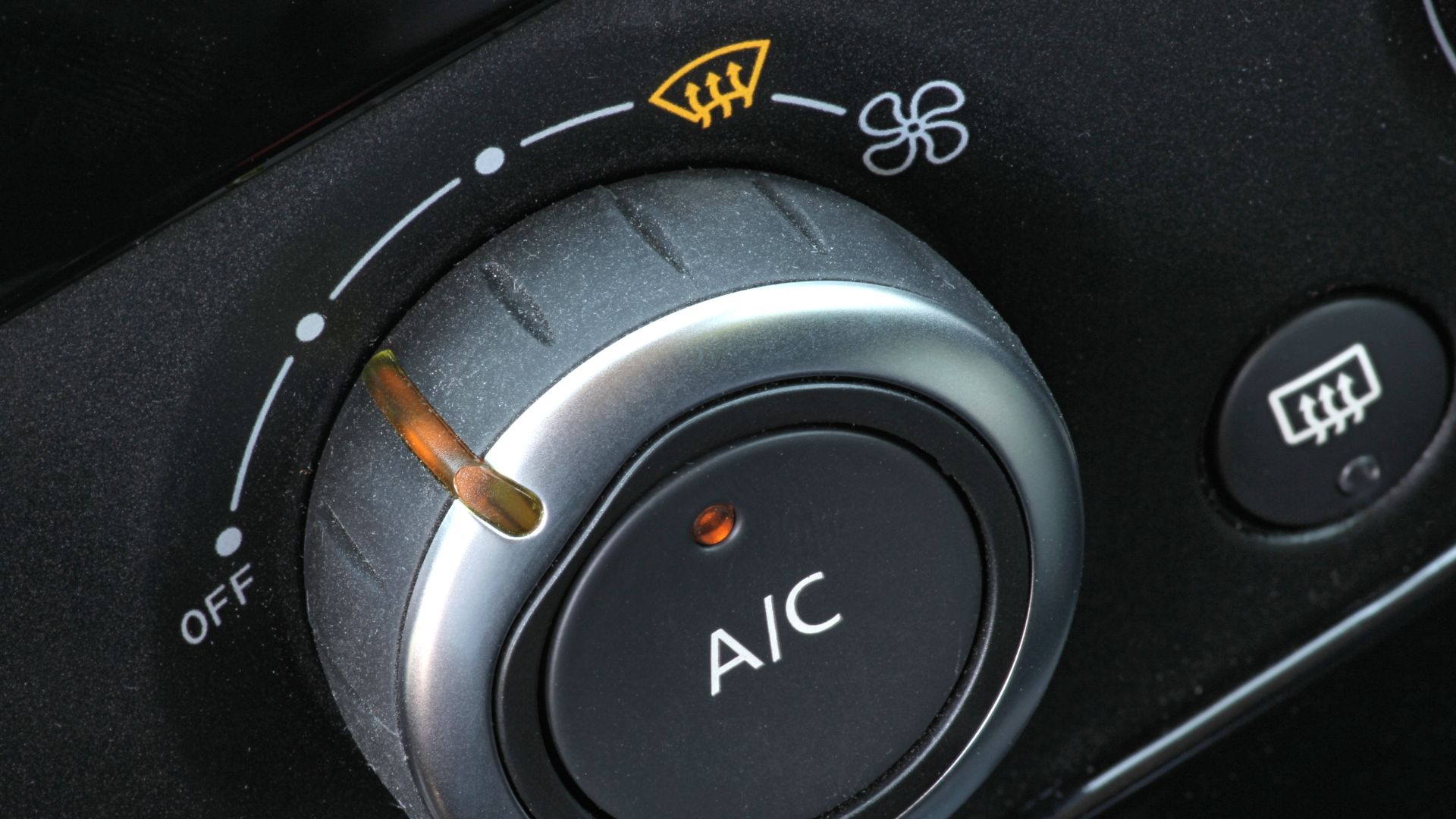 a close up of a button on a car.|a close up of a propane bottle with a hose connected to it.|a close up of a air vent in a car.