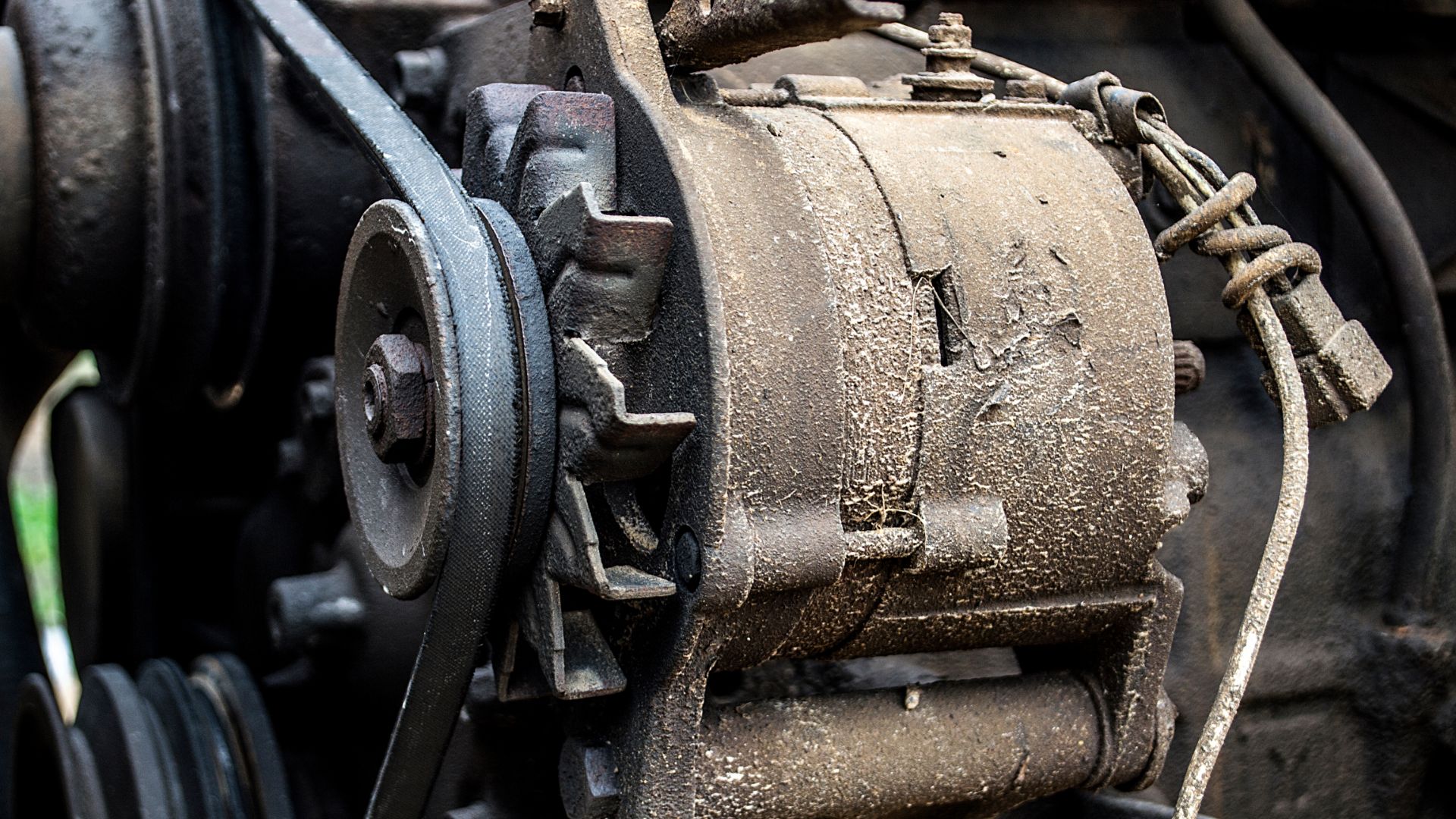 a close up of an old train engine.|a close up of a person wearing a glove.|a close up view of a motorcycle engine.|a close up of a motor on a table.|a close up of a motorcycle engine in the grass.|a close up of the engine of a car.|a close up of a person working on a machine.
