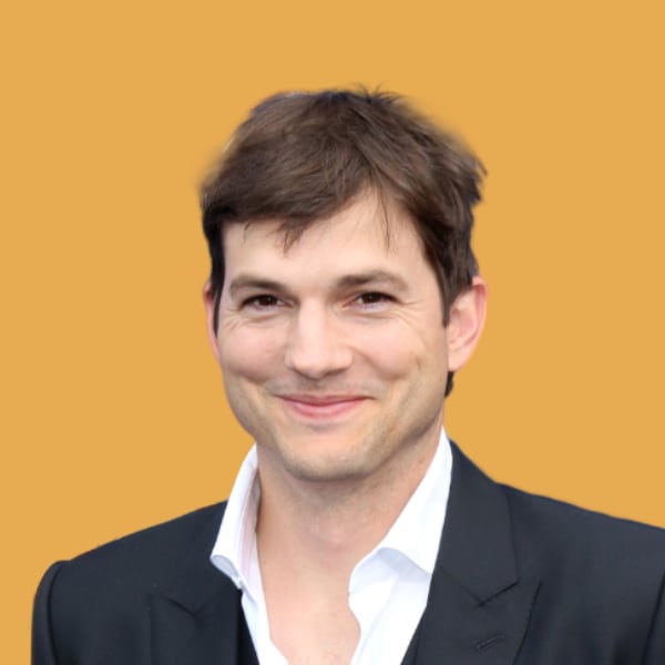 a man in a suit smiling for the camera.