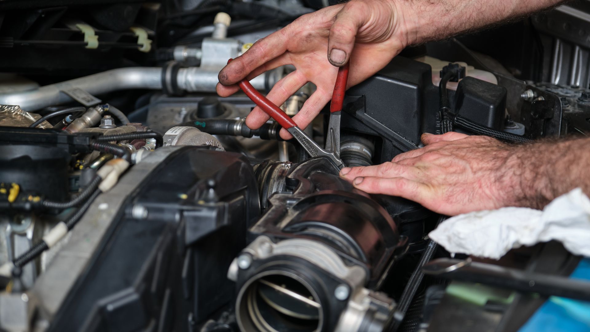 a man is working on a car engine.|a person is working on a car engine.