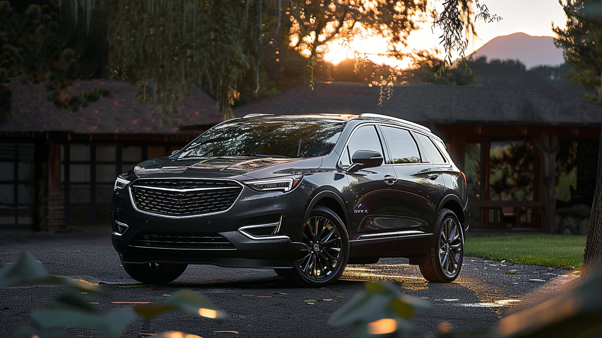 The 2020 Buick Enclave, one of the years to avoid, is parked in front of a house.|a black buick suv parked in front of a mountain.