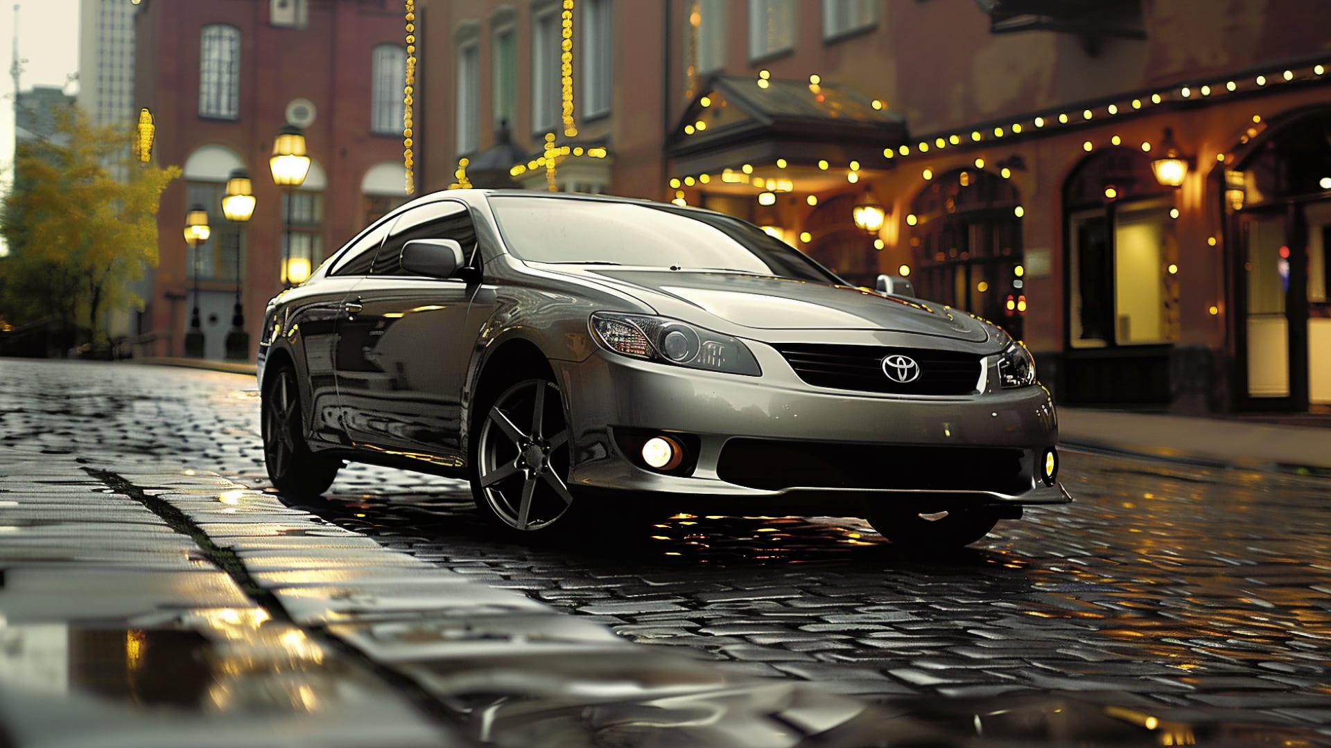 A silver Toyota Solara parked on a cobblestone street.|a silver car parked in front of a building.|a red convertible car driving down a road.