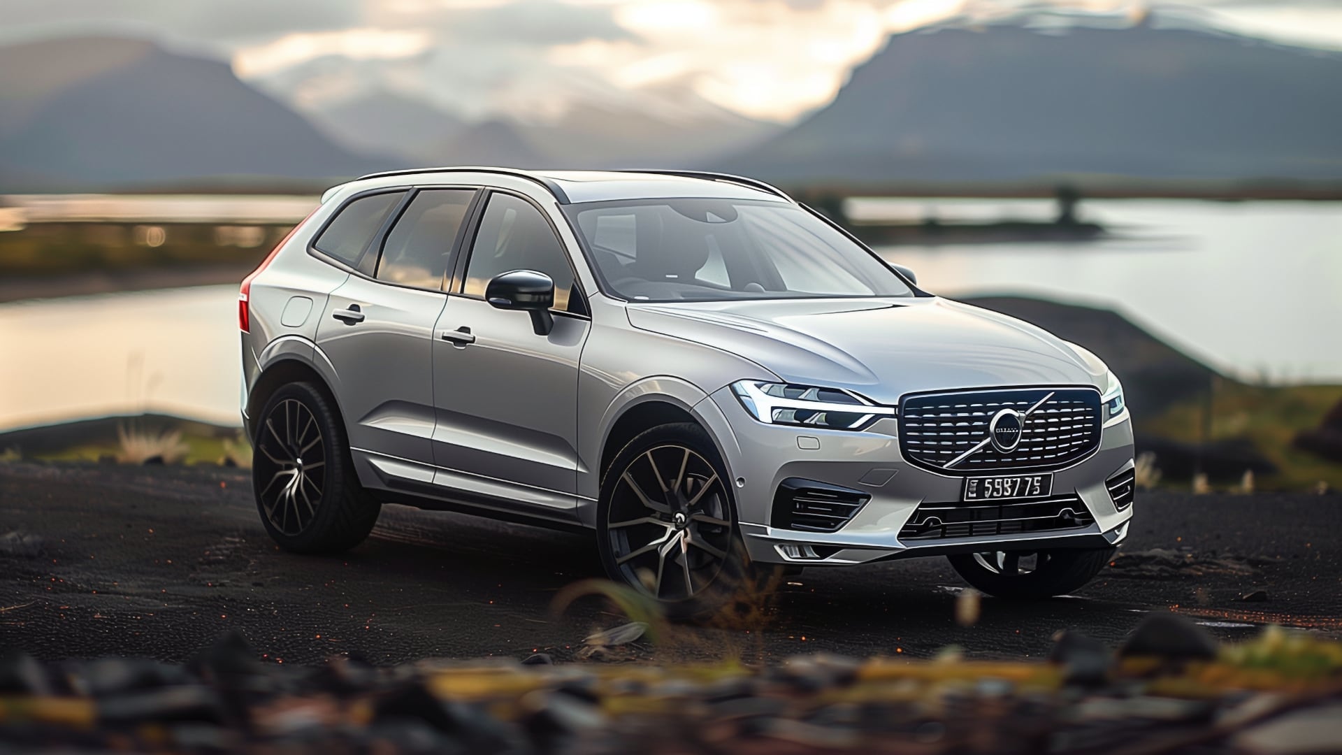 A silver Volvo XC60 on a road.|a silver volvo car parked in front of a stone wall.