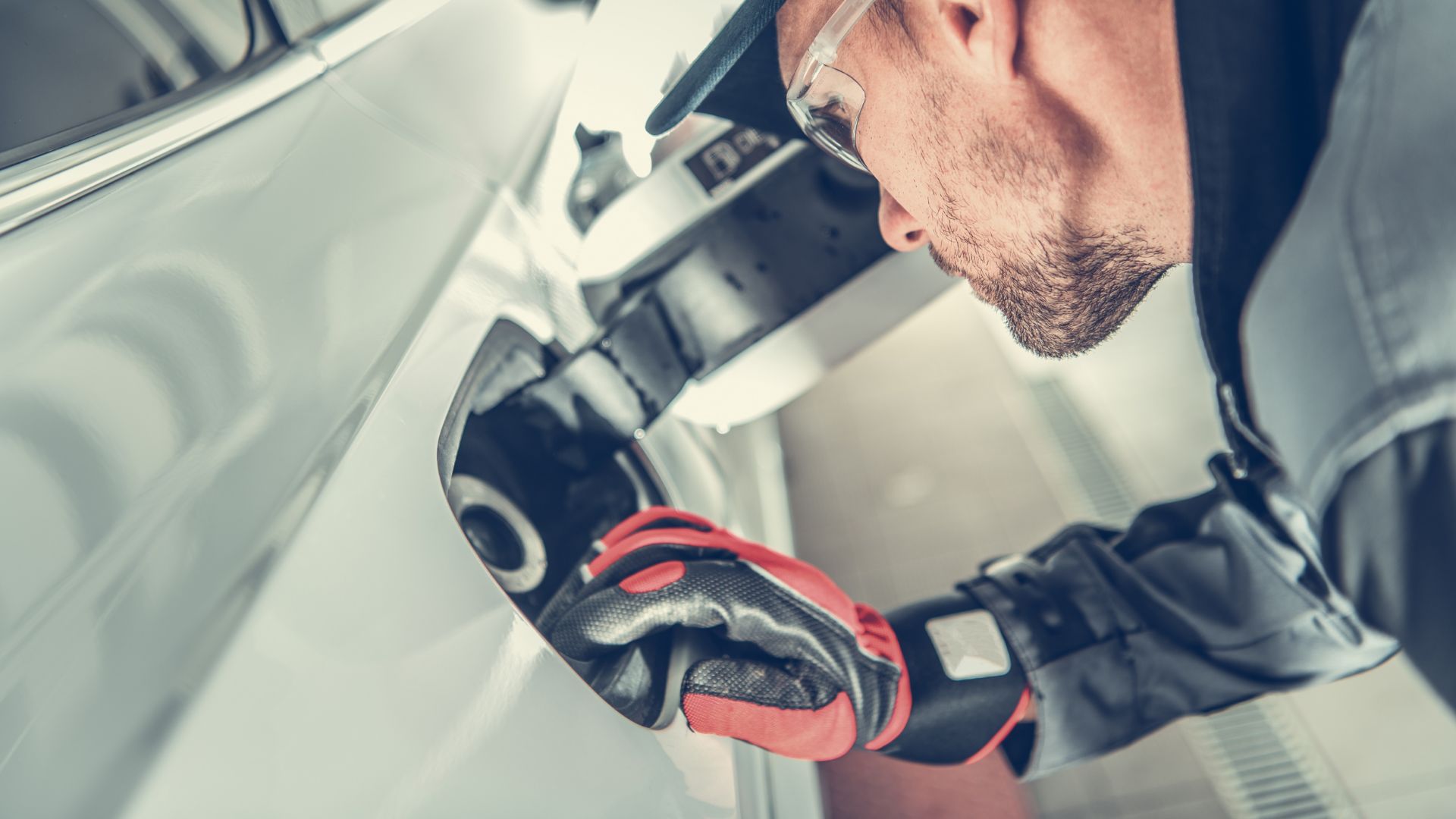 a man wearing a helmet and gloves working on a car.|a close up of a metal object with rust.