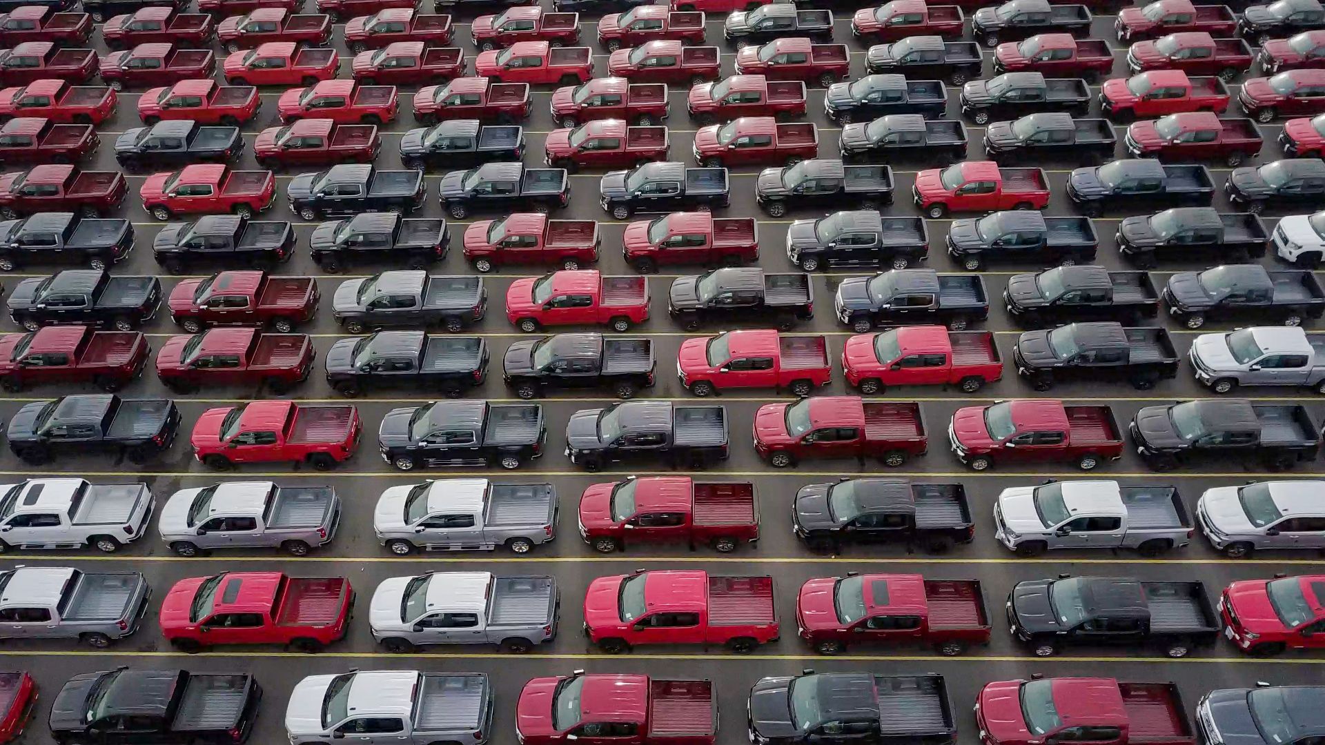 a large parking lot filled with lots of cars.|a green sports car parked in front of a building.|a red car parked on the side of a road.