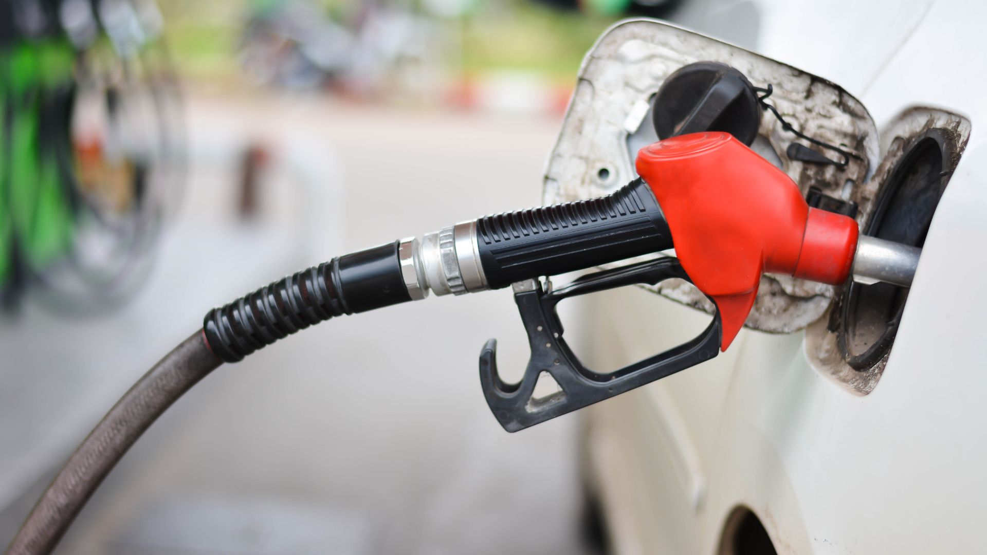 a white car with a red gas pump.|a close up of the engine of a motorcycle.