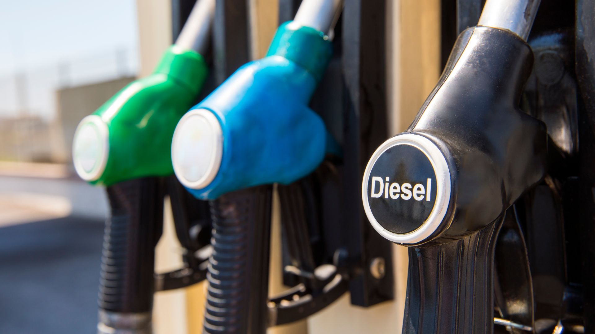 a close up of a gas pump nozzles.|a close up of two gas pumps at a gas station.|a close up of the engine of a car.|a mechanic working on a car engine.