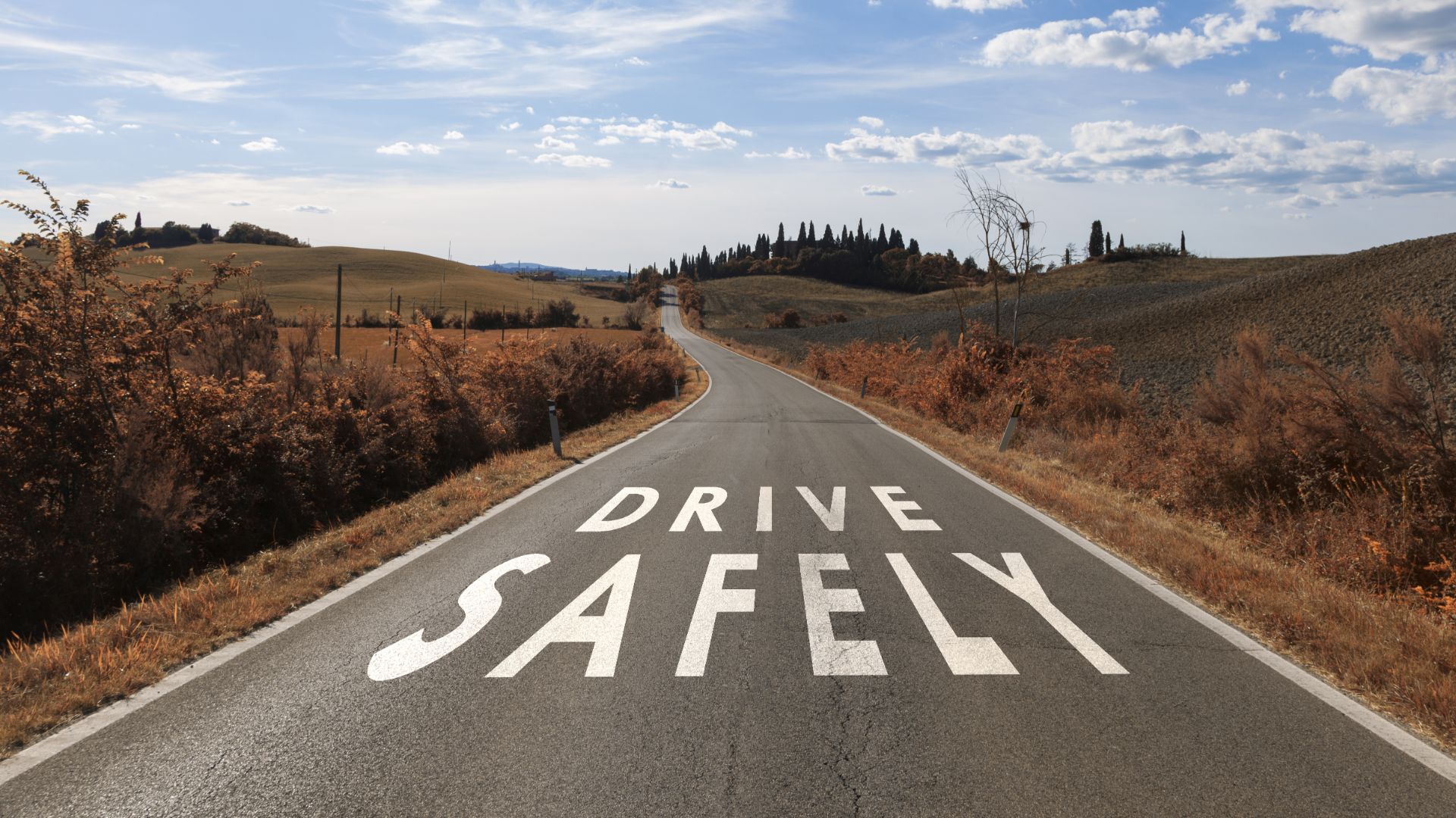 an empty road with a drive safely painted on it.|a close up of a speedometer on a car.|a white car driving down a street next to a speed limit sign.|a speed limit sign sitting on the side of a road.
