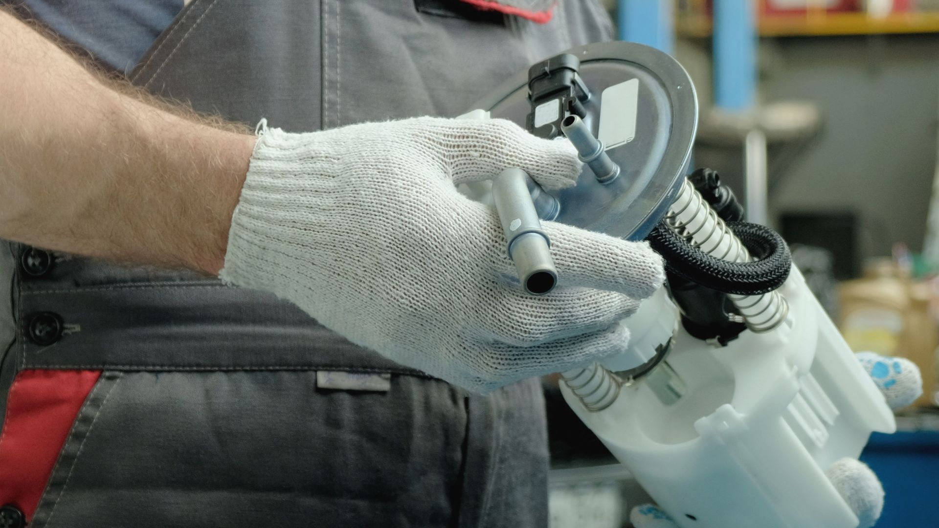 a man is holding a sprayer in his hand.|a man is working on an electrical device.