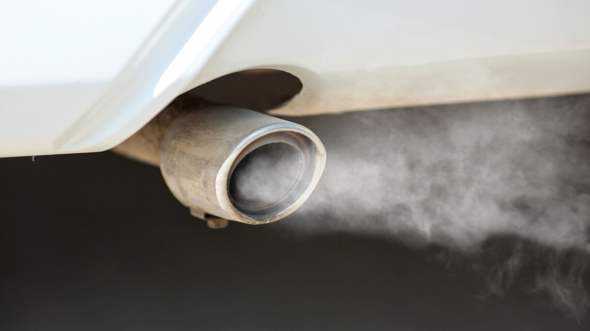 smoke coming out of the exhaust pipe of a car.|smoke coming out of the exhaust pipes of a car.