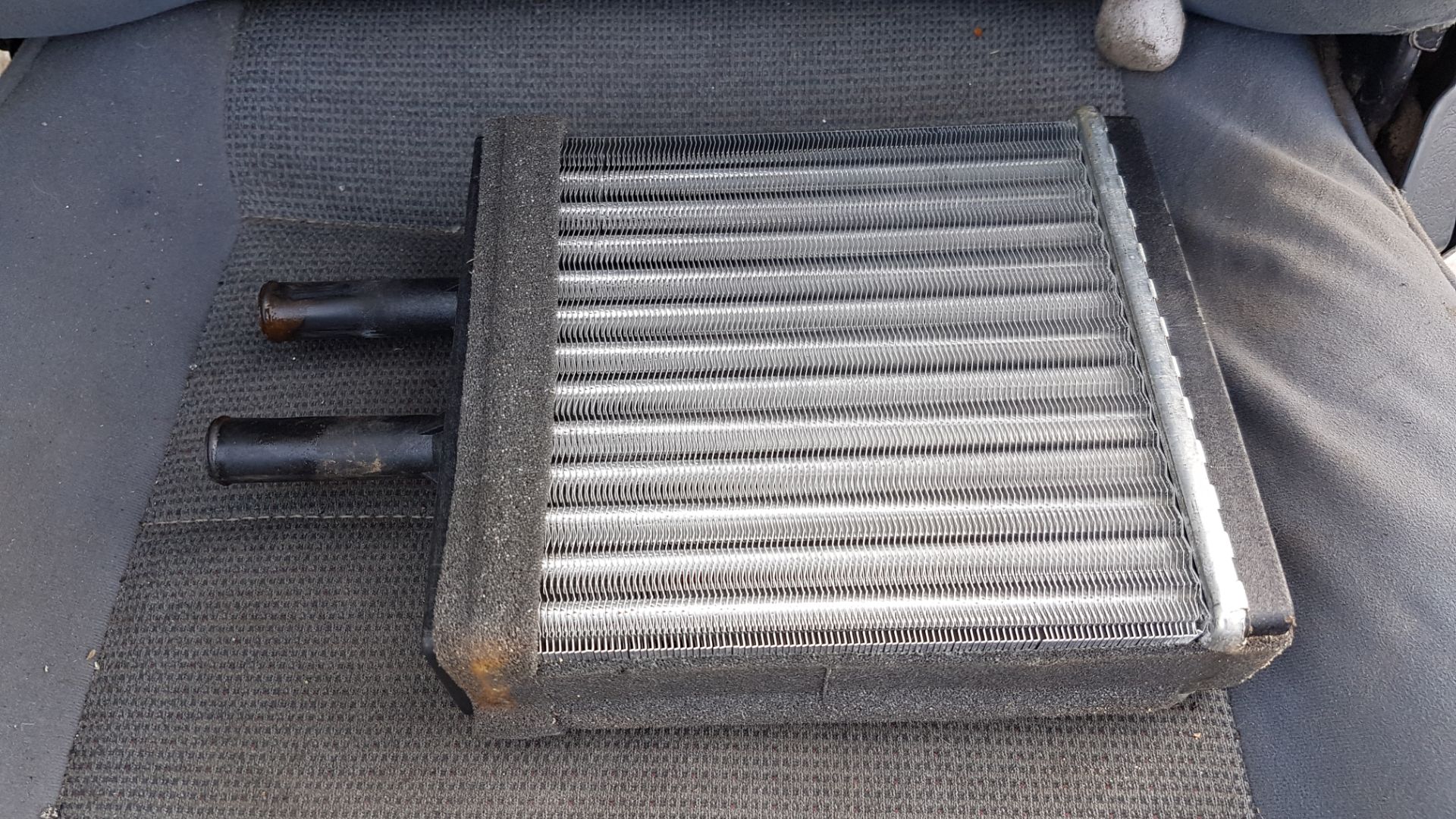 a close up of a radiator on a vehicle.|a pile of burnt wood and debris next to a fire hydrant.