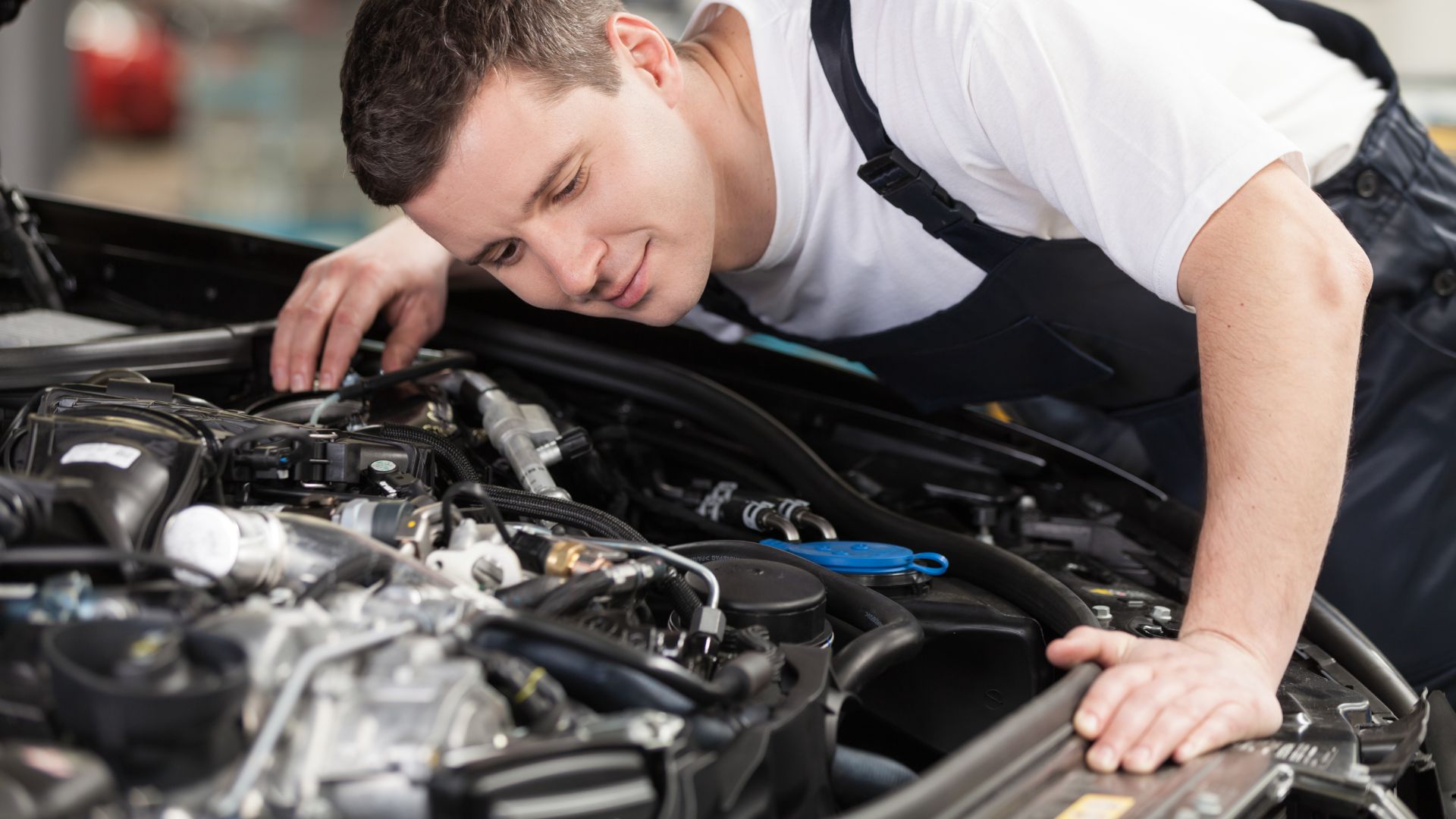 a man working on a car engine in a garage.|a close up of a motorcycle exhaust system.
