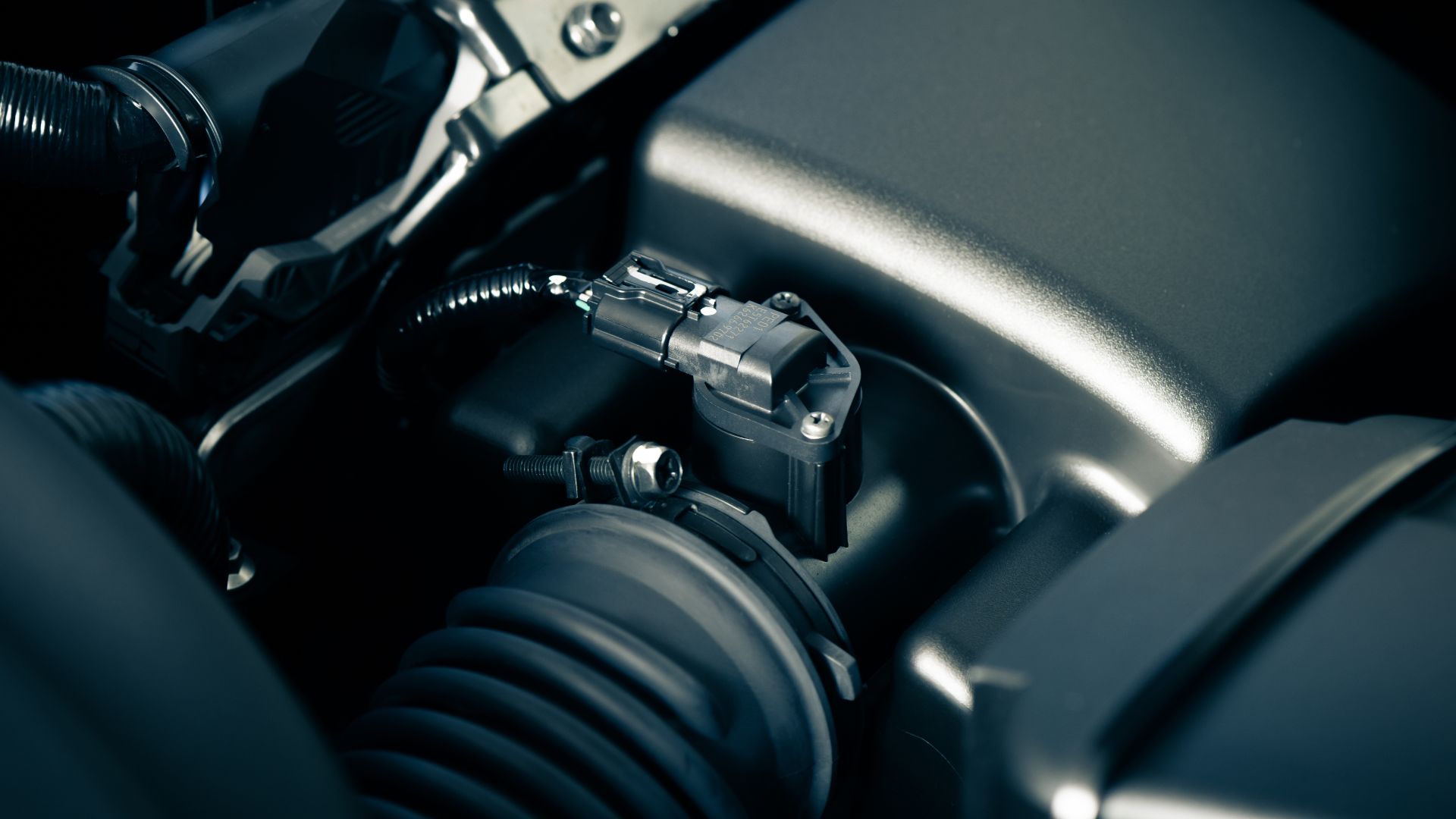 a close up of a car's engine with wires attached.|a close up view of a car's engine.