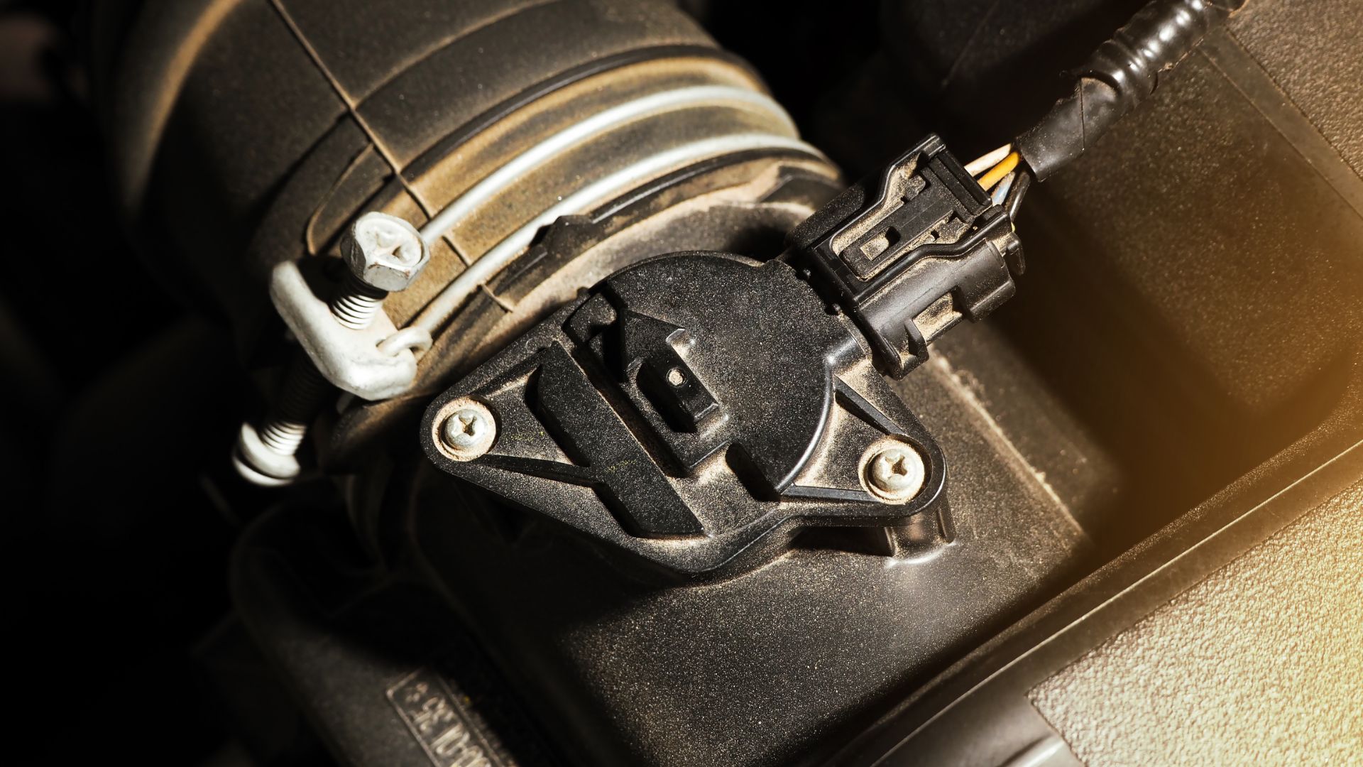 a close up view of a car's fuel pump.|a close up of a car charger on a white background.|a man working on a car in a garage.