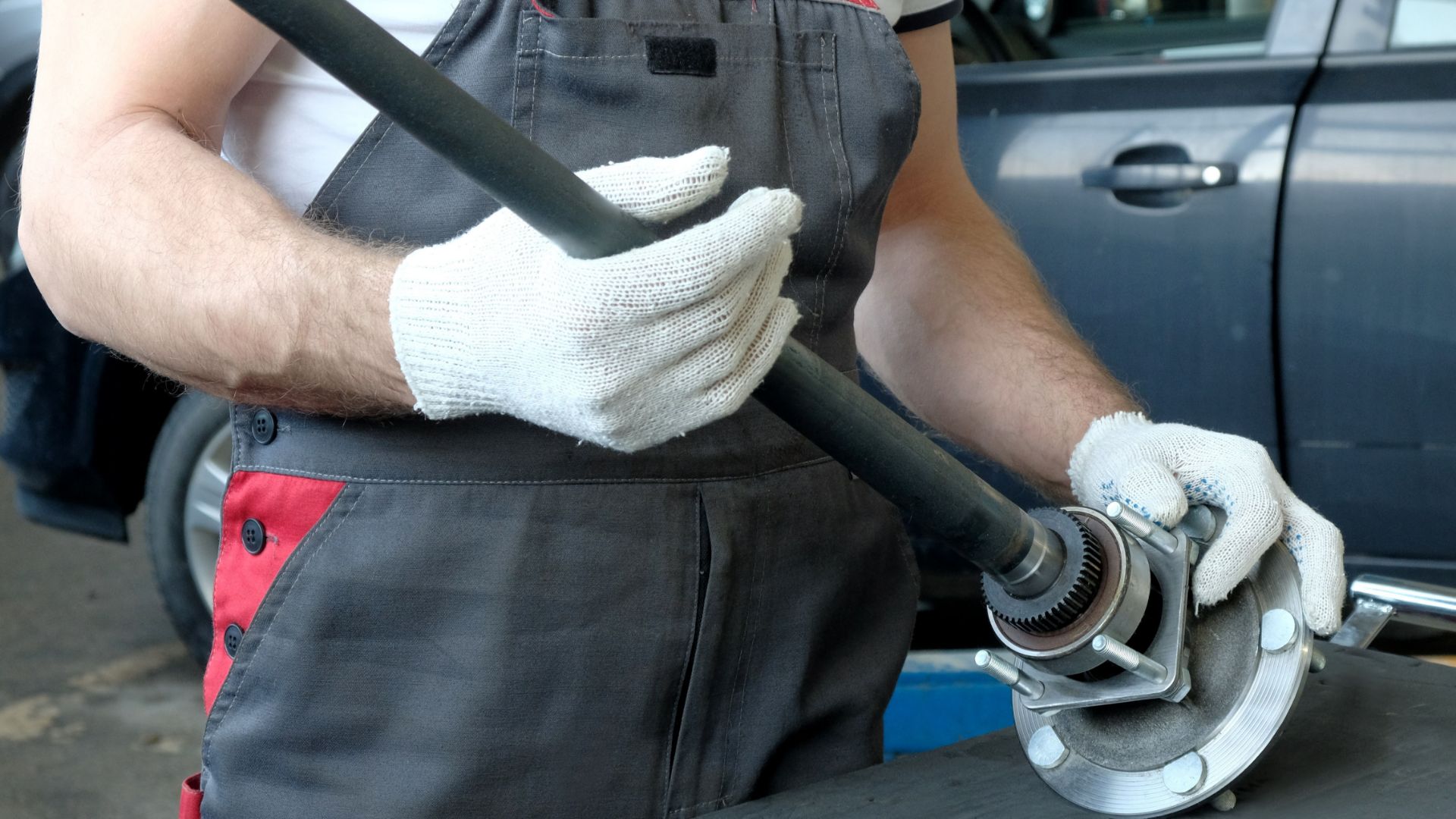 a man holding a wrench in his hands.|a close up of a metal object on a white background.|the front suspension of a vehicle.