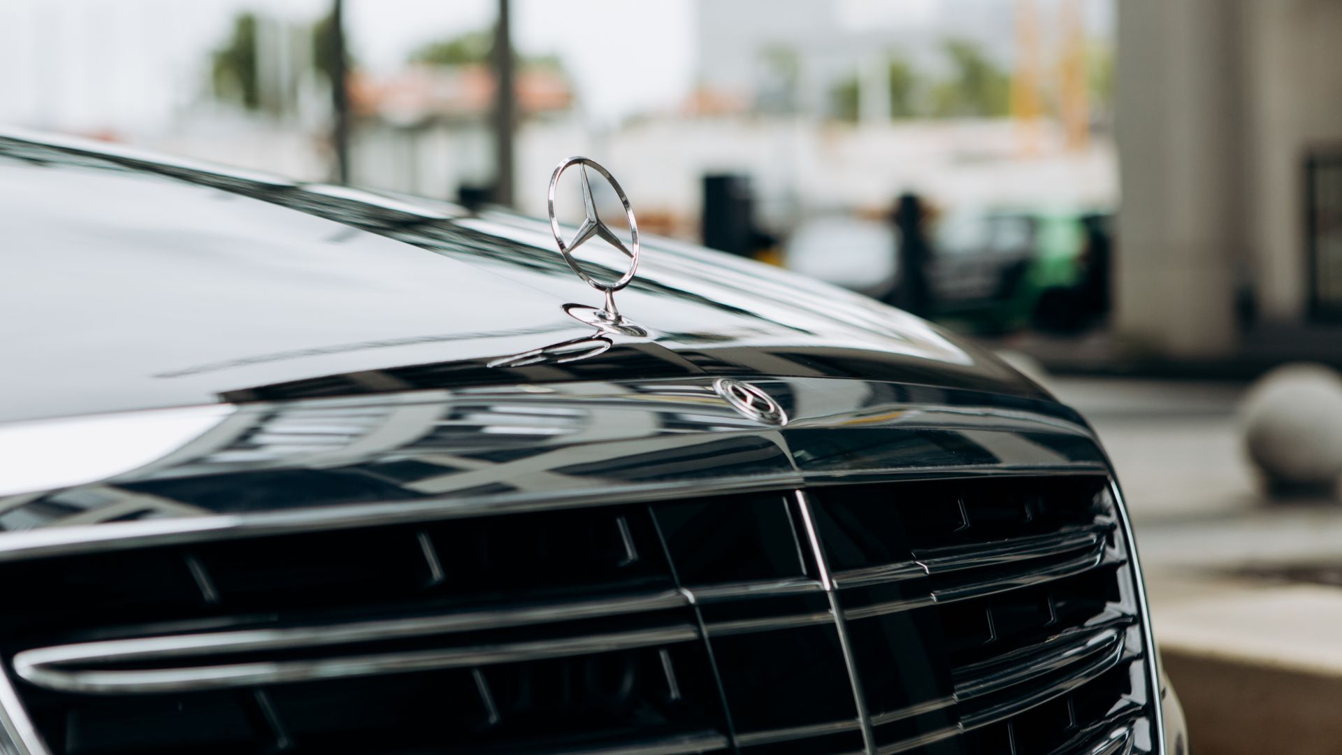 a close up of the front grill of a car.|a row of parked cars sitting next to each other.|a black mercedes benz benz benz benz benz benz benz benz benz benz benz benz benz.