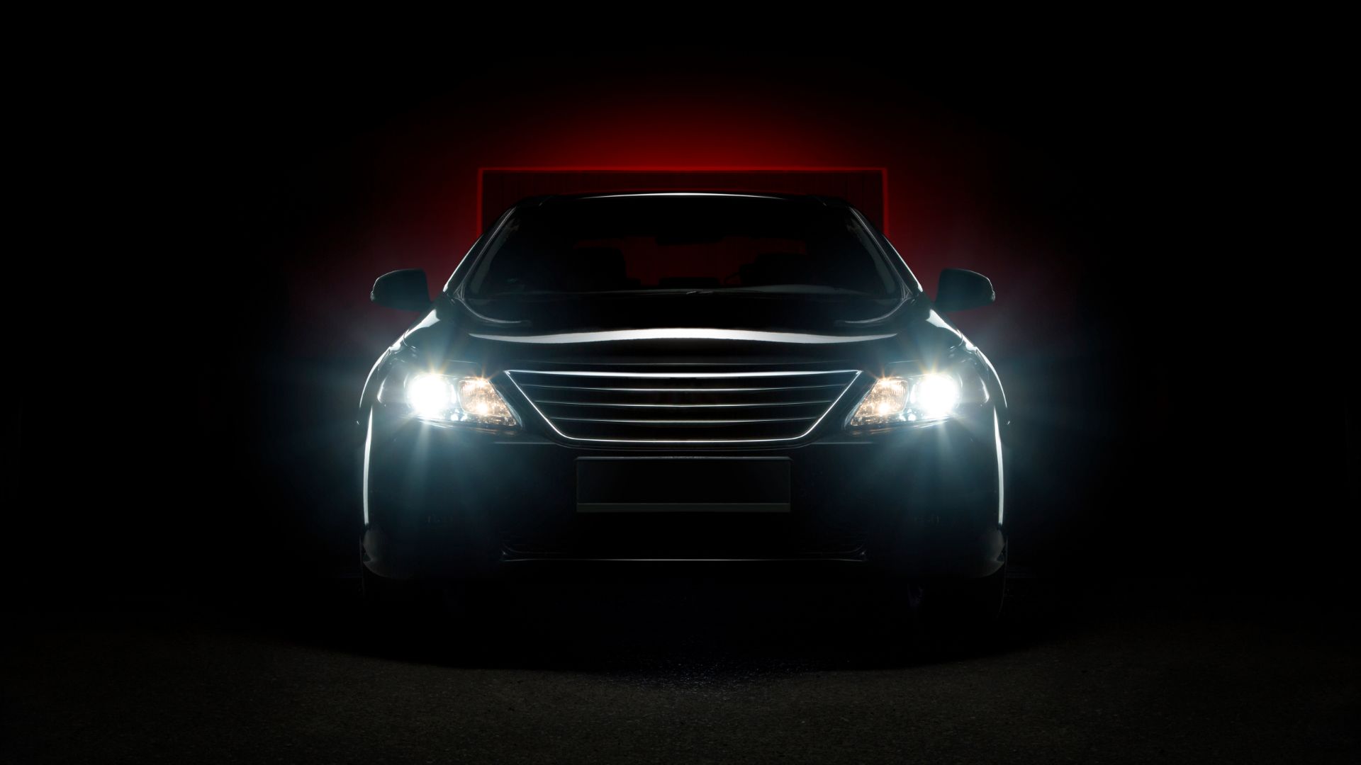 a car with its headlights on in the dark.|a person holding a small light bulb in their hand.|a close up of the headlight of a blue car.|a close up of the headlights of a blue car.|a close up of the front of a car.|the front lights of a car in the dark.