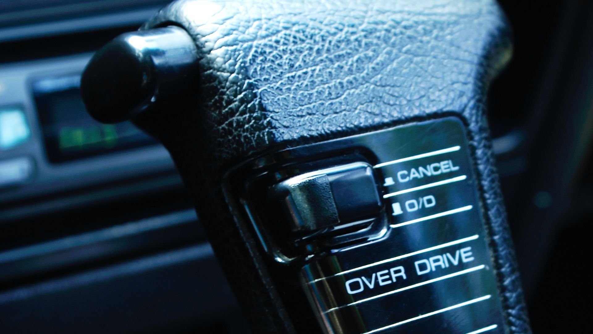 a close up of a button on a car radio.|a close up of a car's gear lever.
