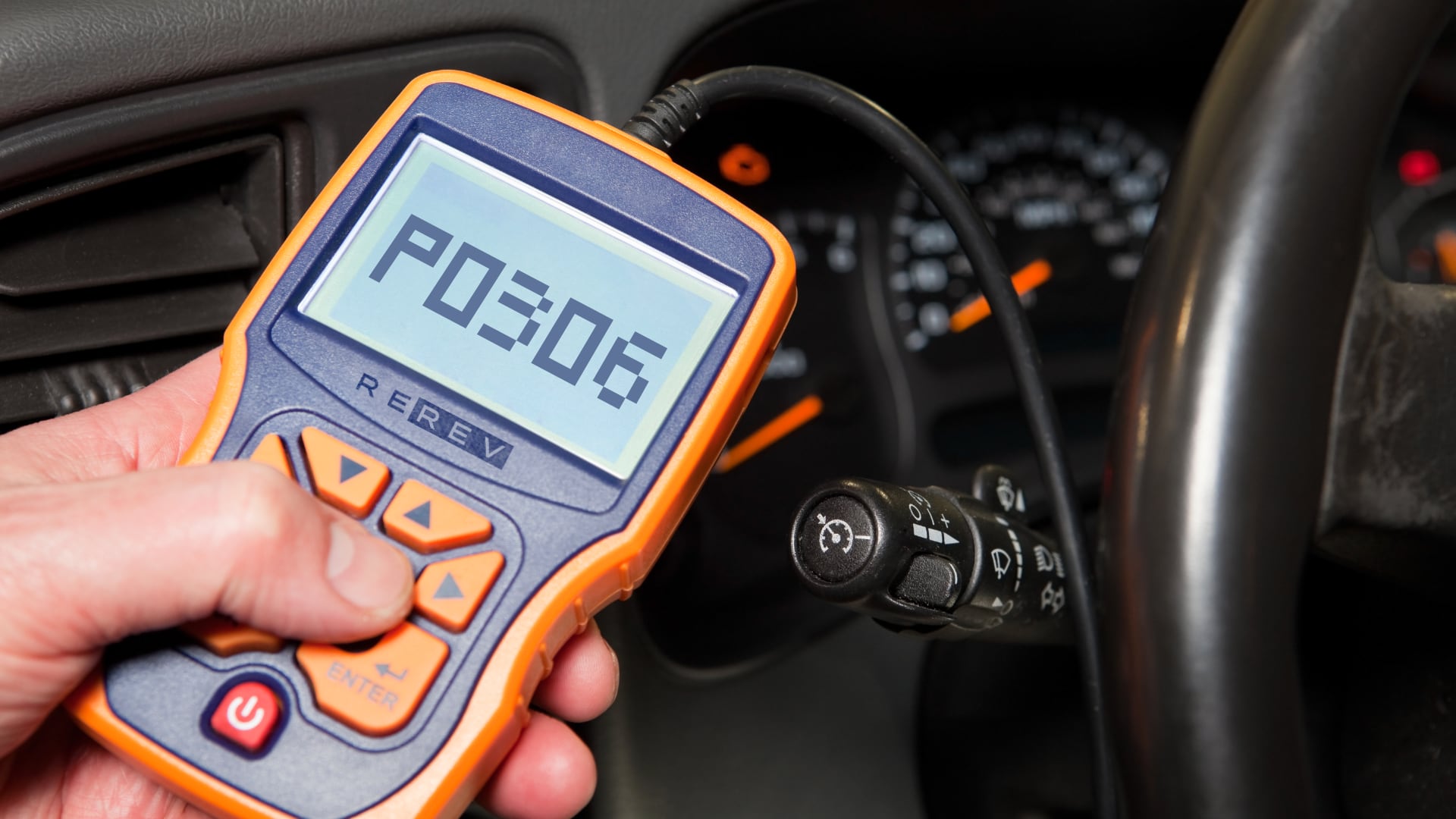 A person holding a pso sensor in a car.