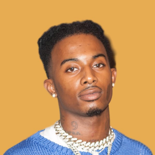 a man wearing a blue sweater and a necklace.