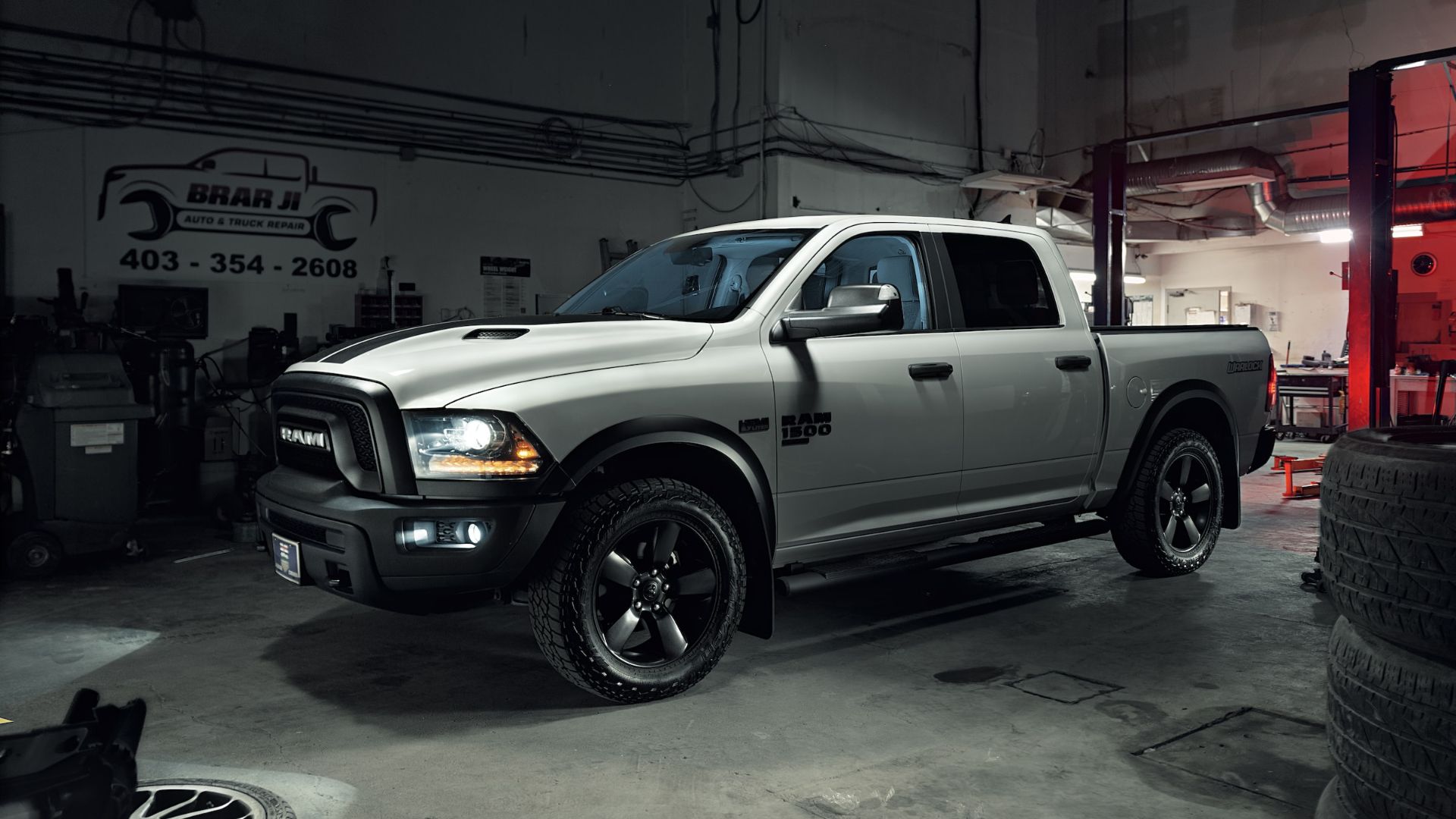 a white truck parked inside of a garage.|a silver truck parked on the side of the road.
