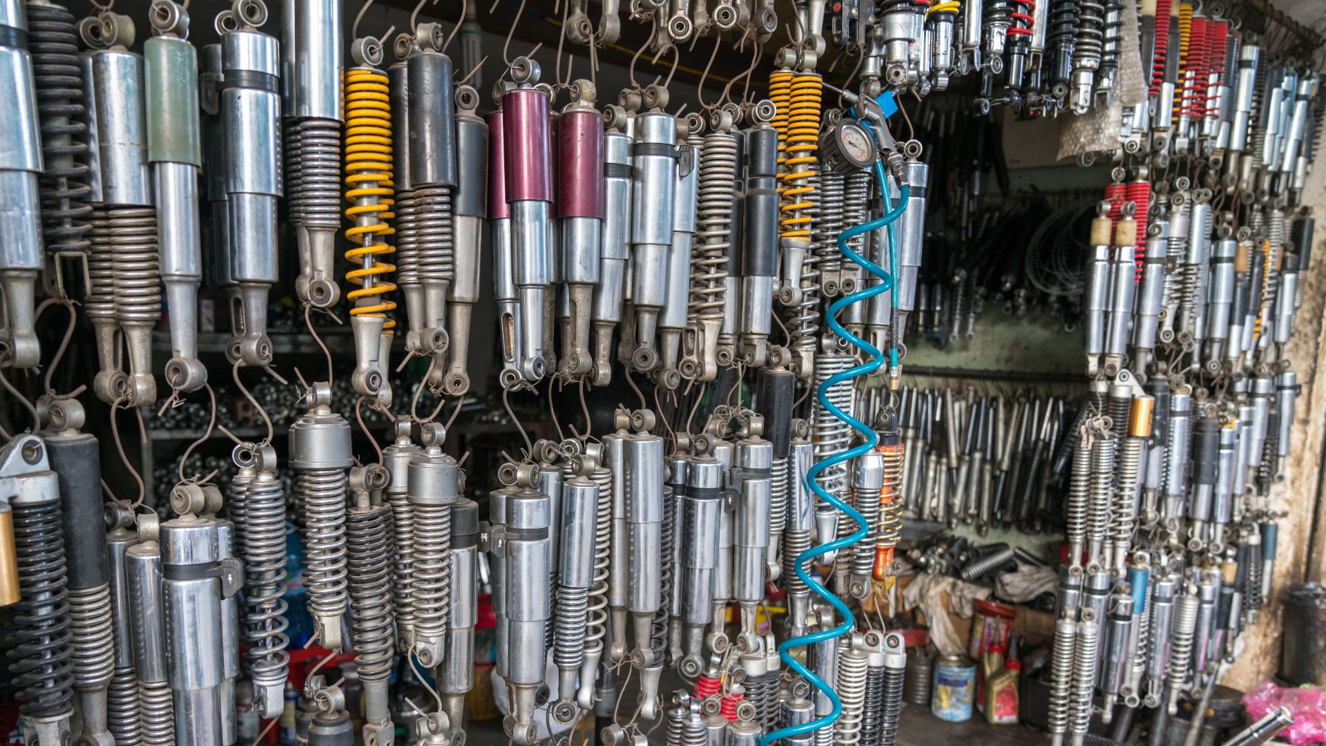 a bunch of different types of wires hanging on a wall.|a close up of a car's front suspension.
