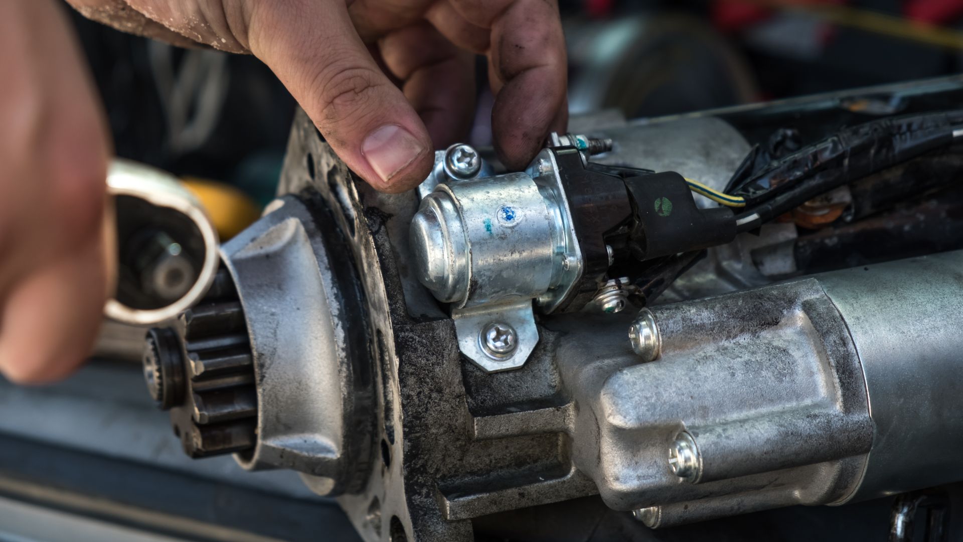 a close up of a person working on a motor.|a pile of metal objects that are stacked on top of each other.