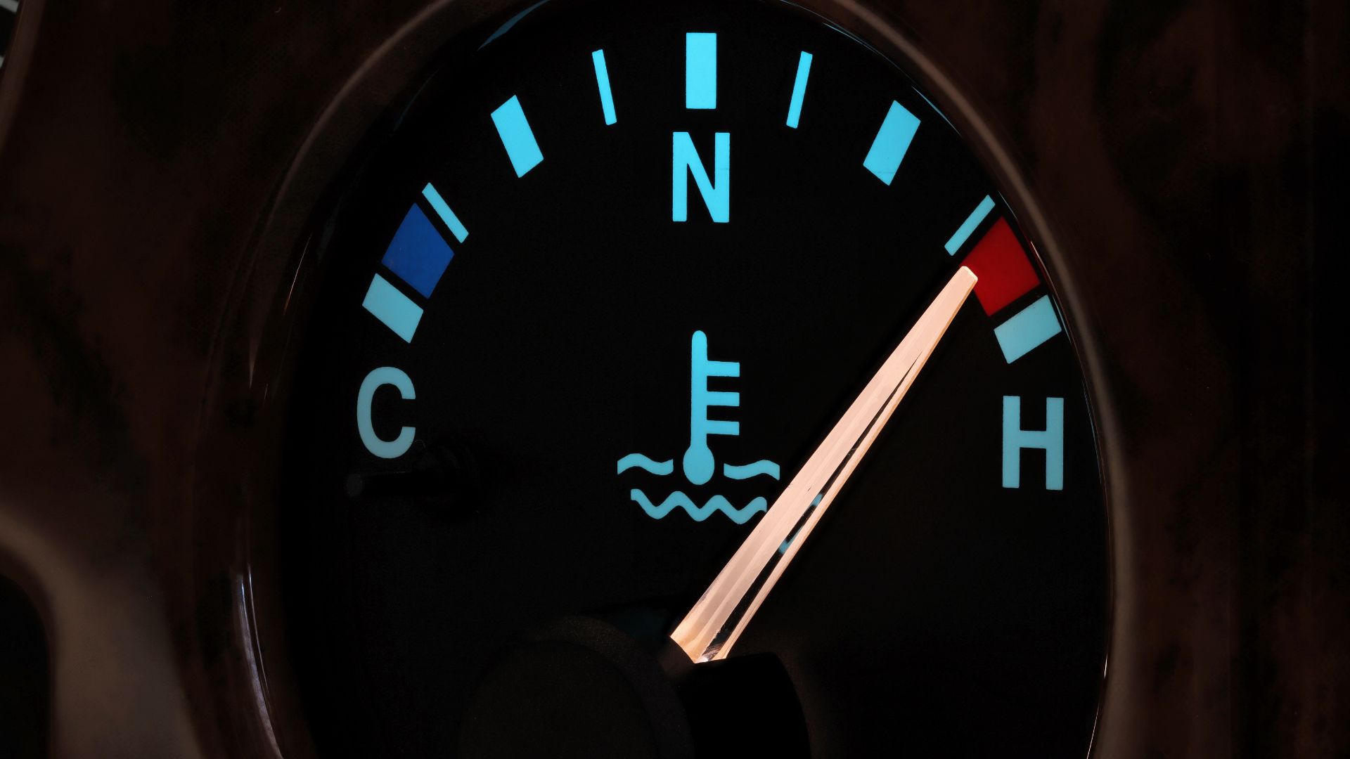 a close up of a speedometer on a vehicle.|a man working on an engine block in a garage.|a person in a blue jacket is pouring a red liquid into a car engine.