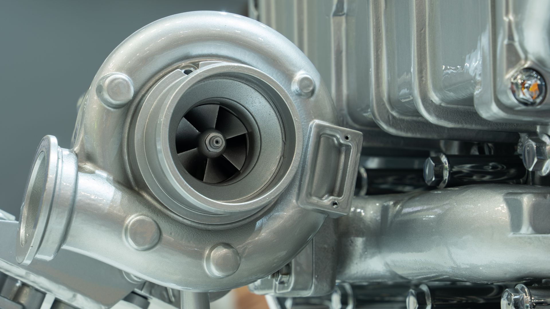 a close up view of a metal object.|a man holding a car engine in his hands.